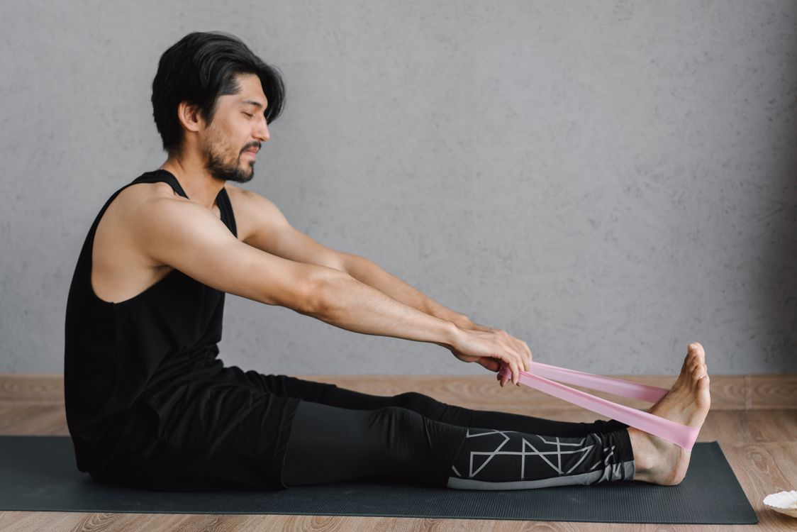Homme s'étirant avec bande de résistance - entraînement à la maison